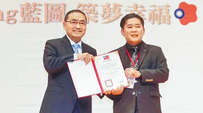 新北市长侯友宜（左）24日颁发社会优秀青年代表当选证书，由中华民国身障棒垒协会理事长潘玮杰（右）受奖。（刘玮晴摄）