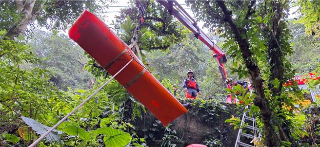 消防人员给与长背板、颈圈、SKED固定，利用器材车吊挂，协助黄翁脱困。（新北市消防局提供）