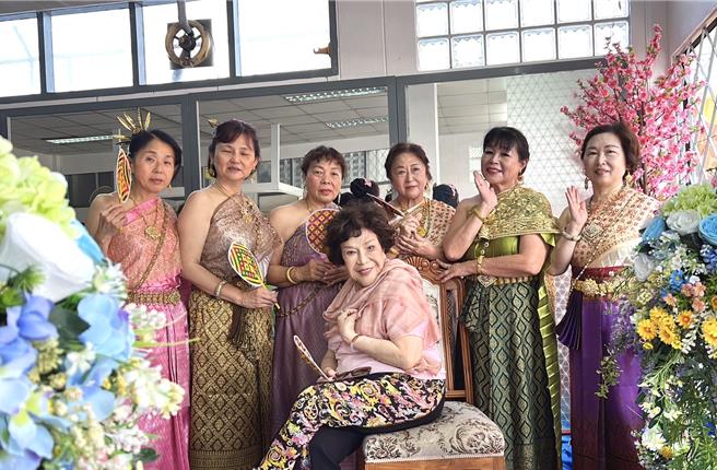 阿姑（前）和穿著泰國傳統服飾的女子們合照。（李朝永提供）
