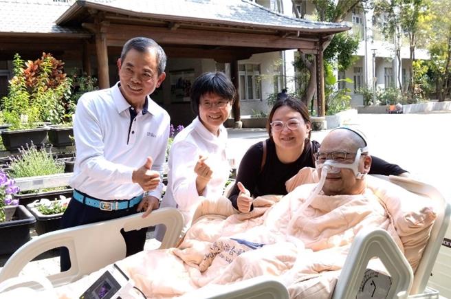 台中慈濟醫院心蓮病房護理長黃美玲（左二）、醫療志工（左一）陪伴黃鼎承（右一）與黃太太（右二）到病房外吸收陽光的滋潤。（台中慈濟醫院提供）