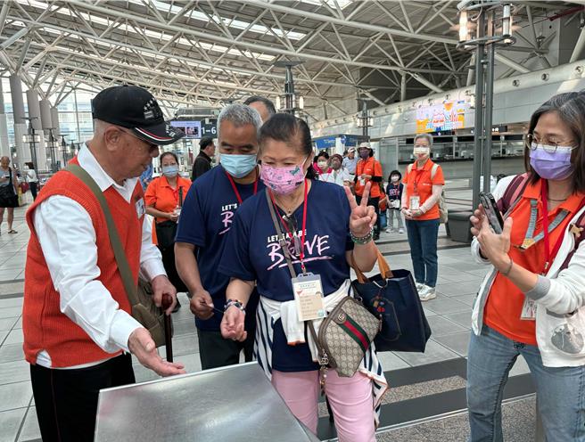 經高鐵左營站站長顏宏穎指導後，97歲「不老站務員」丁爺爺（左一）自信協助其它長輩過票。（林雅惠攝）