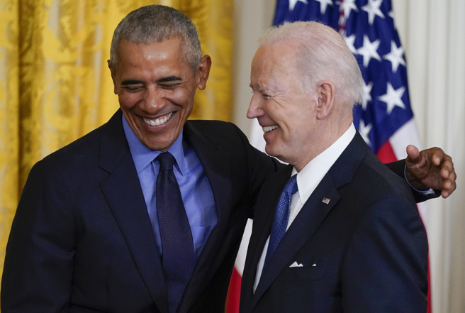 美国总统拜登和前总统欧巴马在白宫东厅（East Room）握手致意的资料照。（美联社）