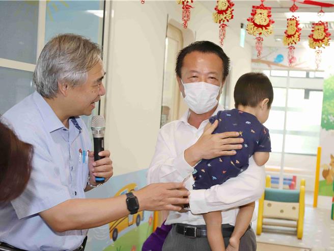 位于嘉义县治特区的太保如亲公共托婴中心今28日正式揭牌，嘉义县长翁章梁抱小宝宝与孩子互动。（吕妍庭摄）