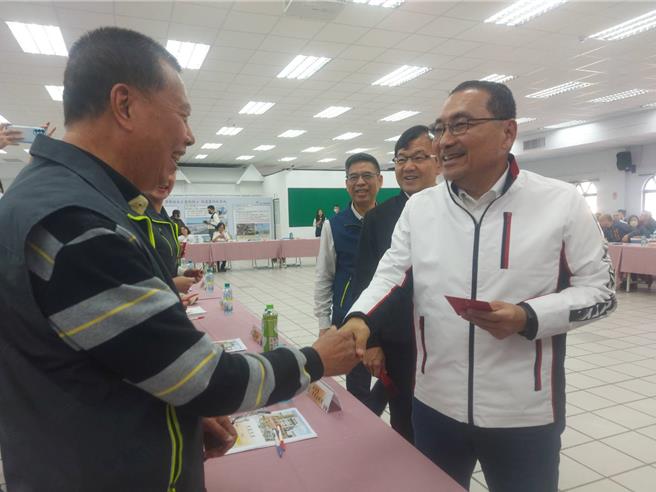 新北市长侯友宜抵达座谈会场后，逐一向每位里长握手致意并发红包。（张铠乙摄）