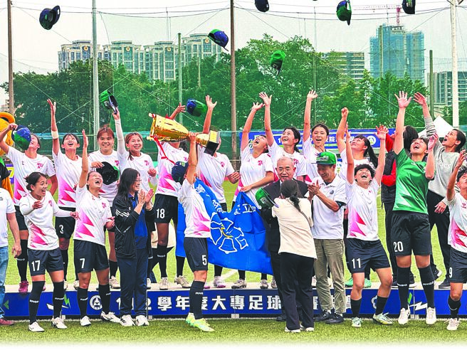 台灣師大在大專足球聯賽女一級決賽衛冕后冠，球員開心高舉金盃，並將帽子拋到空中慶祝。（李弘斌攝）