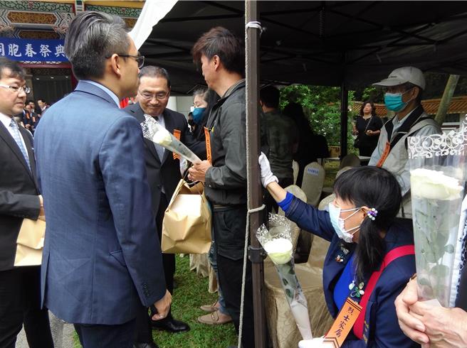 新北市忠烈祠29日举行春祭典礼，新北市长侯友宜（中）担任主祭官，向烈士家属代表递上慰问品。（张铠乙摄）