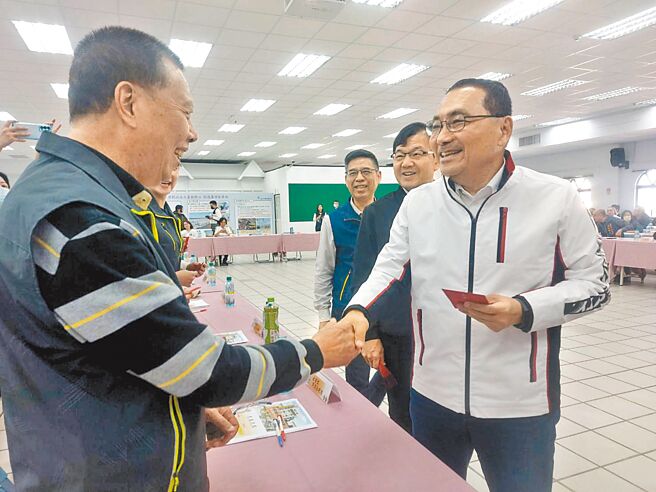 新北市长侯友宜（右一）28日到芦洲参加行动治理座谈会，逐一向每位里长握手致意并发福袋。（张铠乙摄）