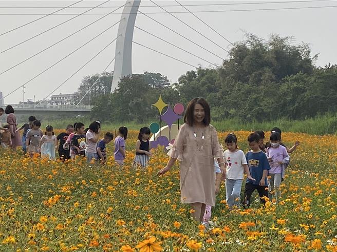 中埔乡长李碧云带孩童体验游赏波斯菊花海。（廖素慧摄）