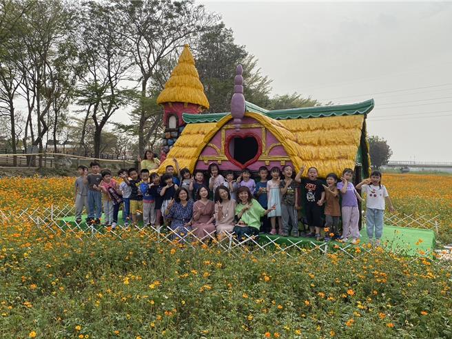 嘉义县八掌溪畔南岸波斯菊盛开成花海，装置艺术姜糖屋吸引游客拍美照。（廖素慧摄）