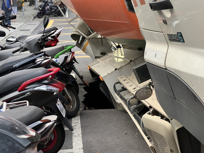 今30日下午17时许，新北市新店中兴路发生地板陷落造成该车倾斜。（图／警方提供）