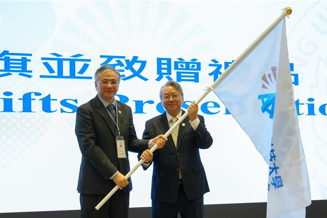 朝阳科大30日举办30周年校庆活动，并成立朝阳科大世界校友联合会，首任会长由令狐荣达（右）担任，由校长郑道明（左）授旗。（朝阳科大提供／陈淑芬台中传真）