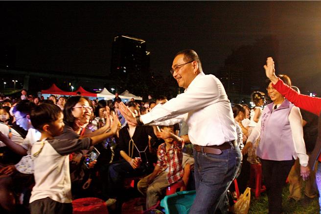 「2024新北童樂節-揪你童在一起」活動30日晚間由紙風車劇團演出唐吉軻德冒險故事「銀河天馬」，新北市長侯友宜（前排中）現場與民眾擊掌。（張鎧乙攝）