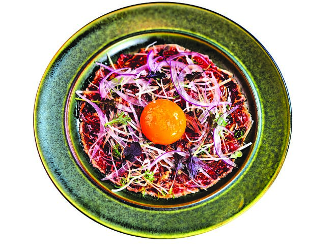 〈炙烧牛菲力佐生蛋黄〉是将USDA冷藏菲力，四面煎炙后薄切，搭配紫洋葱、生食级鸡蛋，并以特制烧肉酱汁提味。图／姚舜