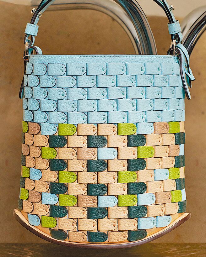 以雙色不同皮革打造而成的Pin Mini Bucket Strap Arsenal-Mosaic青瓷藍提包，售價24萬5900元。（Delvaux提供）