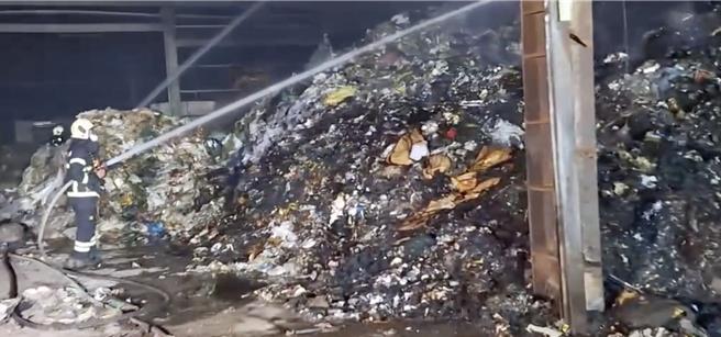 高雄冈山区新乐街发生废弃物场火警，消防局人员到场抢救。（翻摄照片／林瑞益高雄传真）