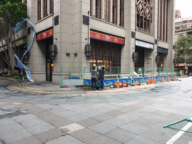 台北市內湖區成功路上的施工圍籬，被怪風吹到東倒西歪，工程人員正在拆除。（翻攝畫面）