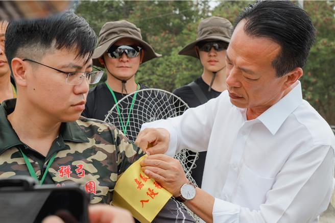 嘉义县长翁章梁视察绿鬣蜥防治野外实作，颁授学员猎人臂章。（嘉义县政府提供／廖素慧嘉县传真）