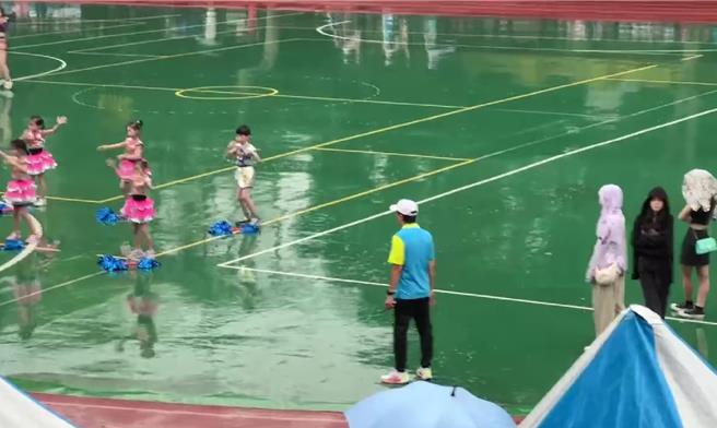 桃园市某国小昨举办30周年校庆运动会，岂料小孩表演时正好碰上下雨，小孩们穿着啦啦队服淋雨跳舞，让家长气得上网发文抱怨，质疑没有雨天备案。(摘自桃园爆报)