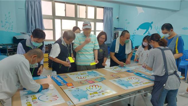 台电高雄区处处长张以诺(左一)与中心的星星儿一起完成电宝创意贴的活动。（台电提供）