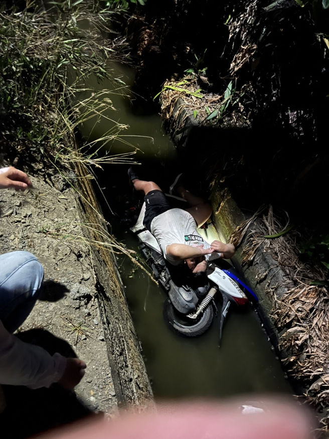 男子騎乘機車在鄉間小路，突然大喊看到鬼，人車就墜落路旁大排水溝裡。（翻攝畫面）