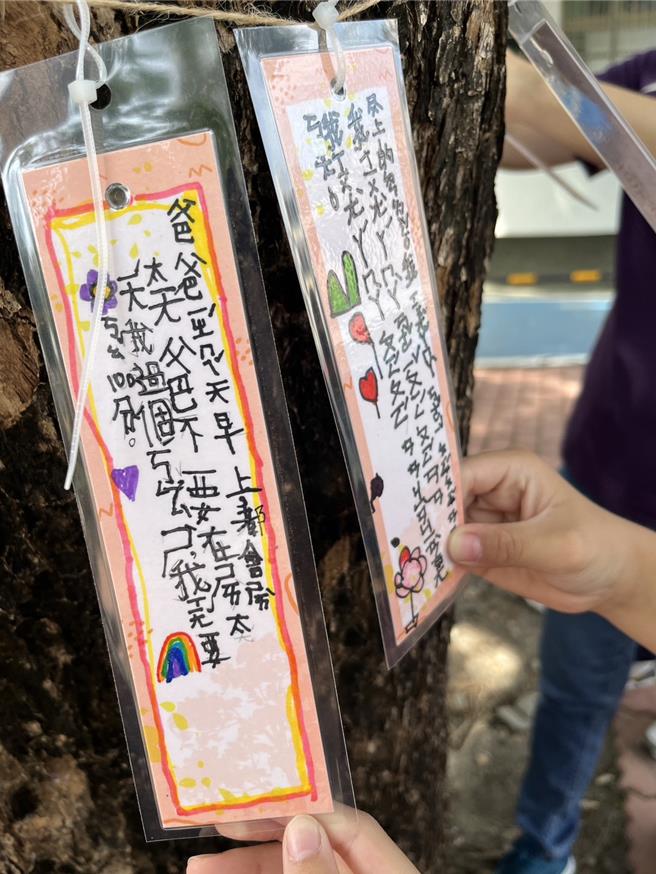儿童节将至，屏东县林边乡仁和国小2日让孩子们写许愿卡挂在树龄55年的校树印度紫檀，为学童送上希望与幸福。（谢佳潾摄）