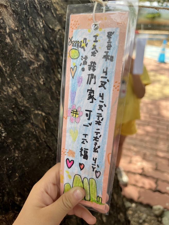 儿童节将至，屏东县林边乡仁和国小2日让孩子们写许愿卡挂在树龄55年的校树印度紫檀，为学童送上希望与幸福。（谢佳潾摄）