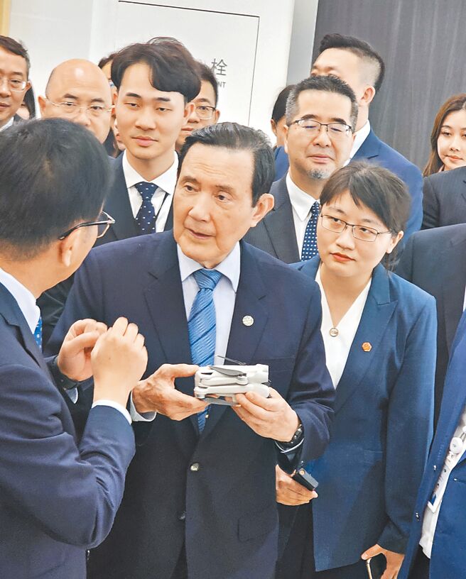前总统马英九（中）1日率领「大九学堂」20名青年学子赴陆参访，第一站前往大疆新创公司。解说员拿了一个很轻巧的无人机，约225公克，让马英九亲手来惦惦看重量。（蓝孝威摄）