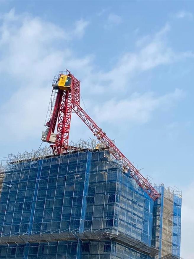 新庄某建案大楼顶楼吊车吊臂因强震倾倒。（新北市新庄警分局提供／吕健豪新北传真）