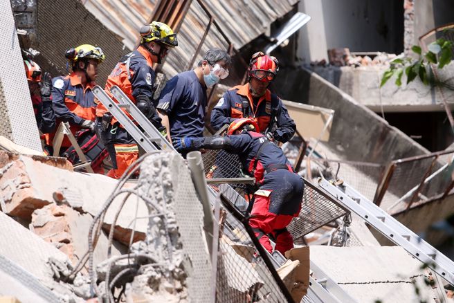 中和区连城路一处仓库倒塌，厂房5楼建筑物后半部倒塌，最后一名受困民眾顺利救出，并自行走下废墟，亲友上前拍肩鼓励。（杜宜谙摄）