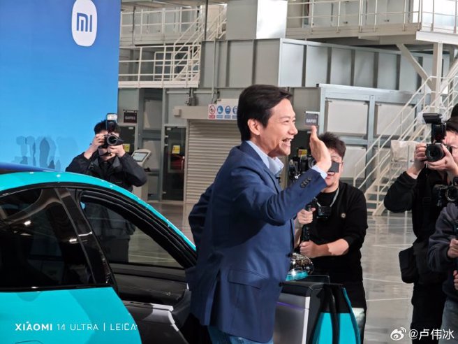 小米董事长雷军在3日的交车仪式上为SU7车主打开车门。（图/翻摄卢伟冰微博）