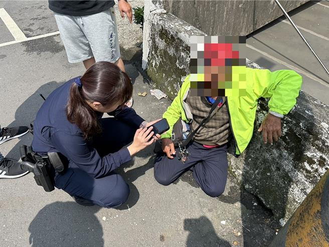 野柳派出所警員黃郁珊協助倒地的吳姓老翁。（金山警分局提供）