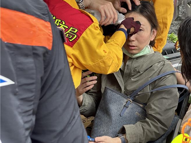 晶英酒店員工獲救下山，朱姓女員工頭部遭利器割傷，表情仍驚恐。（王志偉攝）