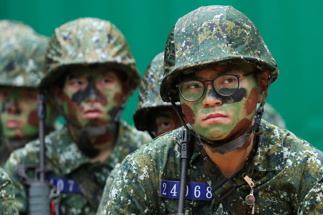 2024年3月20日，成功岭Ｍ脸上涂着迷彩服的义务役兵在新训鑑测前在旁边等候资料照。（路透社）