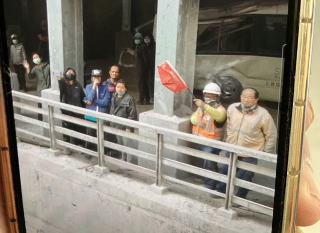 受困九曲洞晶英酒店员工、游客71人，见空拍机猛摇红旗求救。（稍早画面／消防署提供）