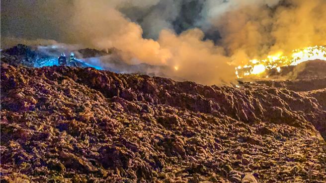 新竹縣新豐鄉新豐垃圾掩埋場4日晚發生沼氣引發的火警，新竹縣消防人員進行灌救。（新竹縣消防局提供／羅浚濱新竹傳真）