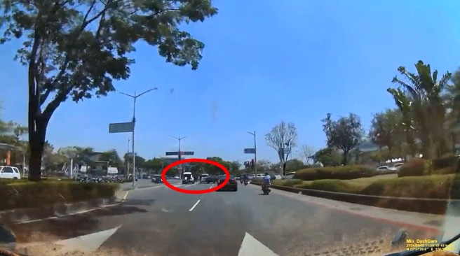 绿灯直行阻挡到闯红灯的白色宾士休旅车，竟然遭对方追车持武器攻击。（翻摄爆料公社）