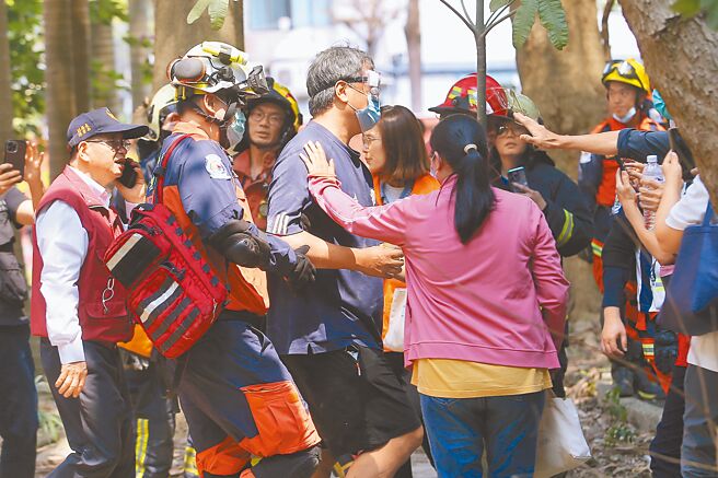 新北市中和区连城路一处5楼仓库建筑物后半部倒塌，警消抵达后救出3男1女共4人，受困民眾脱险后，亲友开心上前拍肩鼓励。（杜宜谙摄）
