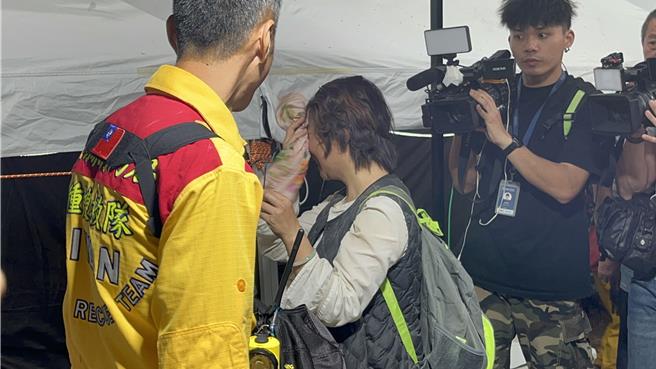 被救下的林姓民眾全身灰泥，疲憊不堪。（王志偉攝）