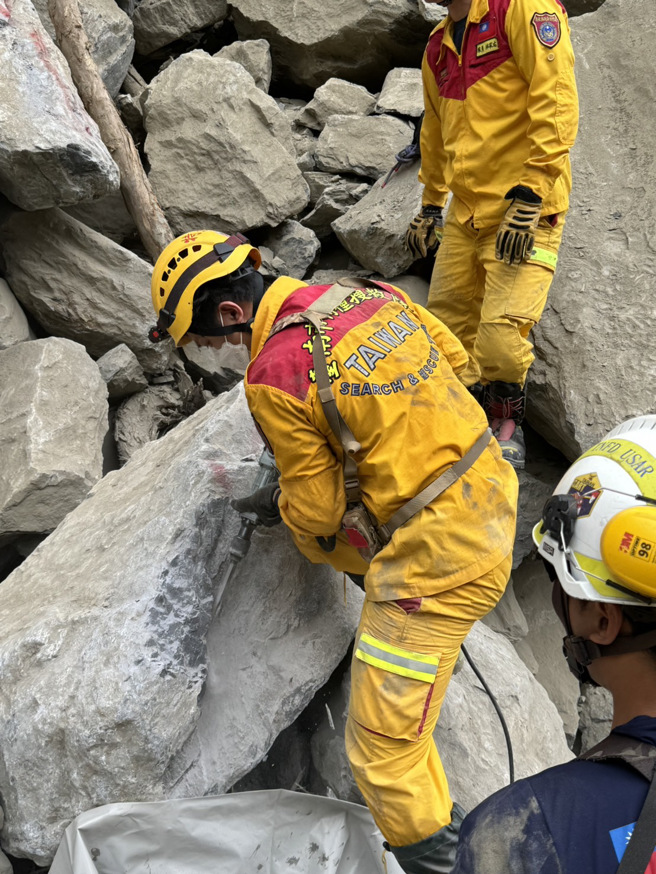 特搜隊員利用電鑽破巨石，搶時間移出被壓在砂卡礑步道的2具遺體。(王志偉翻攝/特搜隊提供)