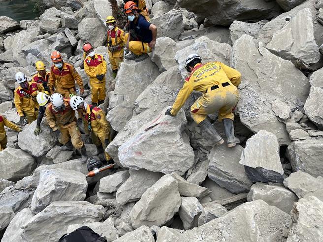 搜救隊在砂卡礑步道發現兩具遺體被壓在大石下，試圖開鑿巨石，效果不好，考慮將與重機械開挖。（特搜隊提供）