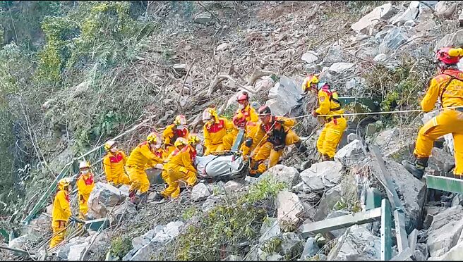 花莲强震再增1死，特搜队4日下午在太鲁阁国家公园小锥麓步道发现一名男子遗体，眾人以接力方式将遗体搬运下山。（屏东县消防局提供）