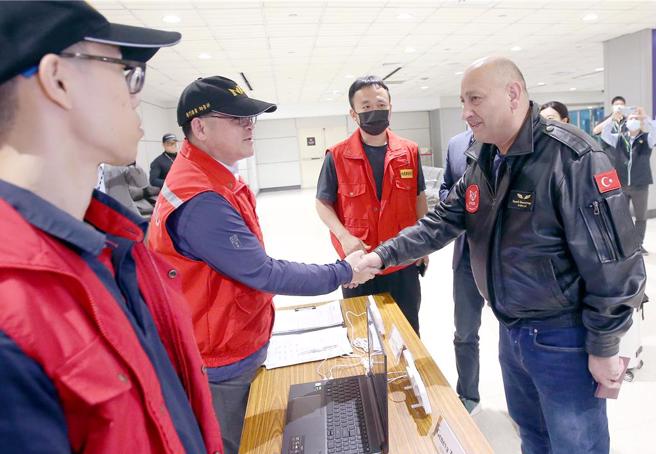 土耳其特搜隊（右）搭機抵台，下機後與接機的中央災害應變中心人員握手致意。（范揚光攝）