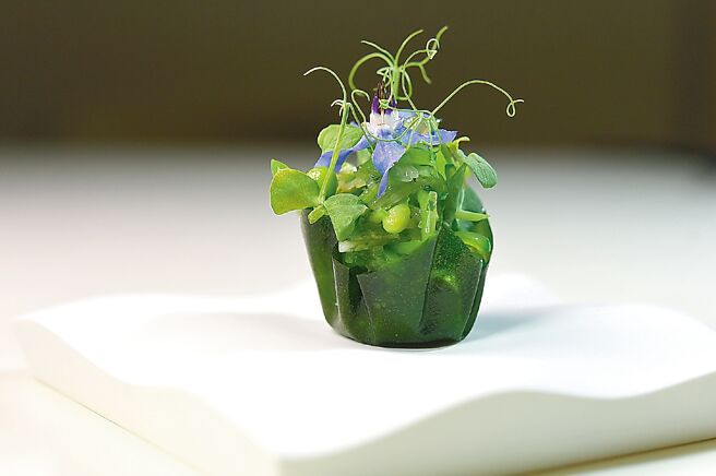 春意盎然的開胃小點〈芥香甜豆白蝦塔〉，以帶有山葵風味的金蓮葉襯底，填入日本富山白蝦仁和芥末甜豆泥，還有豆莢沙拉和小紫花裝飾。圖／姚舜