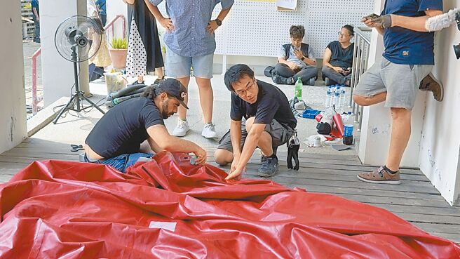 红球计画5日抵达台南市新化街役场展出，但充气过程中，被鹰架刺破1个洞消风瘫软，策展团队现场紧急抢修。（洪荣志摄）