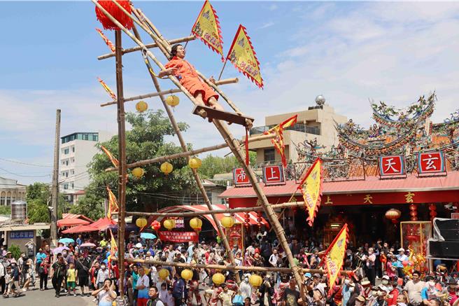 傳承超過200年的嘉義市鞦韆節7日在嘉義市武當山玄天上帝廟廟埕熱鬧展開，不同年齡層的選手們，站在12公尺高鞦韆架上賣力擺盪。（呂妍庭攝）