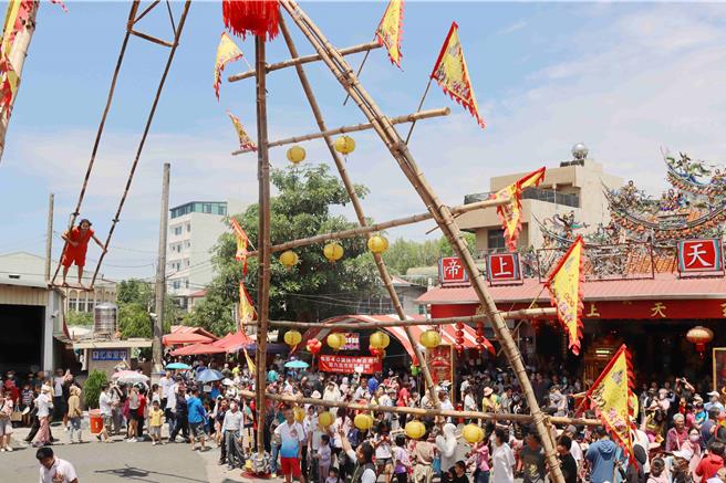 傳承超過200年的嘉義市鞦韆節7日在嘉義市武當山玄天上帝廟廟埕熱鬧展開，不同年齡層的選手們，站在12公尺高鞦韆架上賣力擺盪。（呂妍庭攝）