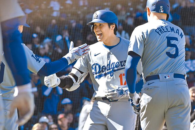道奇大谷翔平（中）連兩天開轟，回到本壘與隊友擊掌慶祝。（路透）