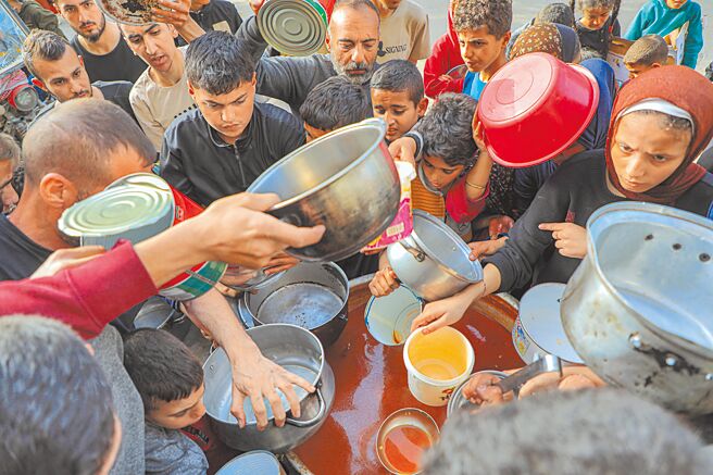 迦萨面临灾难性饥荒的人数达到110万人，英国6日宣布，将派出一艘皇家海军舰艇到迦萨，建立一条人道主义海上走廊。图为迦萨民眾等待领取食物。（新华社）