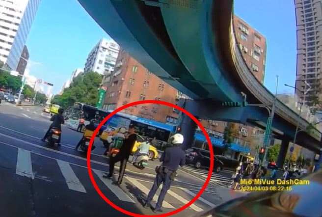 地震發生後，警員正善後地震相關的工作，豈料一名行人卻趁機在誌號燈轉紅時，大搖大擺地過斑馬線，行為引發駕駛不滿。（圖 / 翻攝自「Wwowtchout影音」）