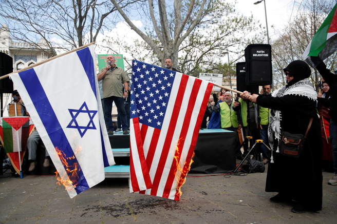 土耳其伊斯坦堡5日参与「圣城日」活动的民眾声援加萨走廊，当街焚烧美国与以色列国旗表达不满。（路透）
